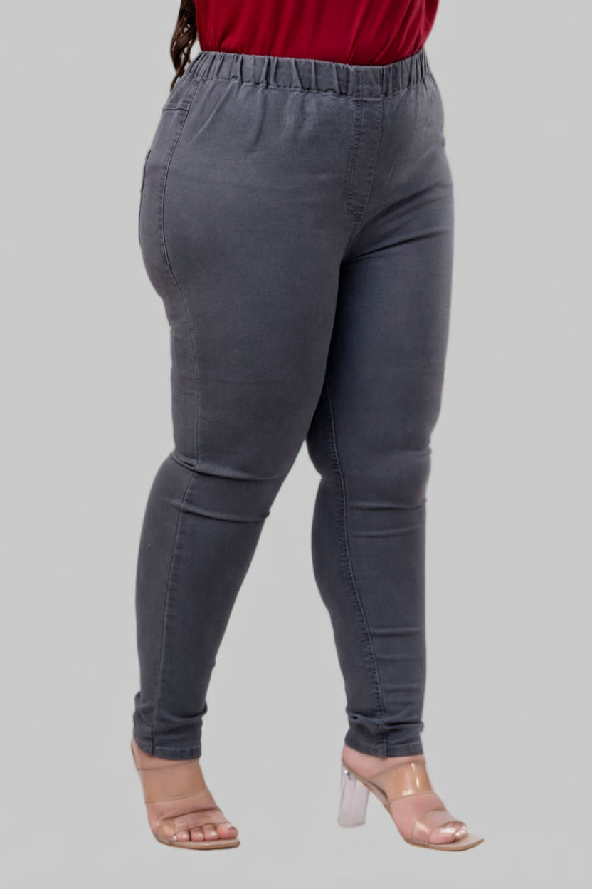 Side pose of plus size grey stretch denim jeggings showing tapered fit and elastic waist – Curvisha