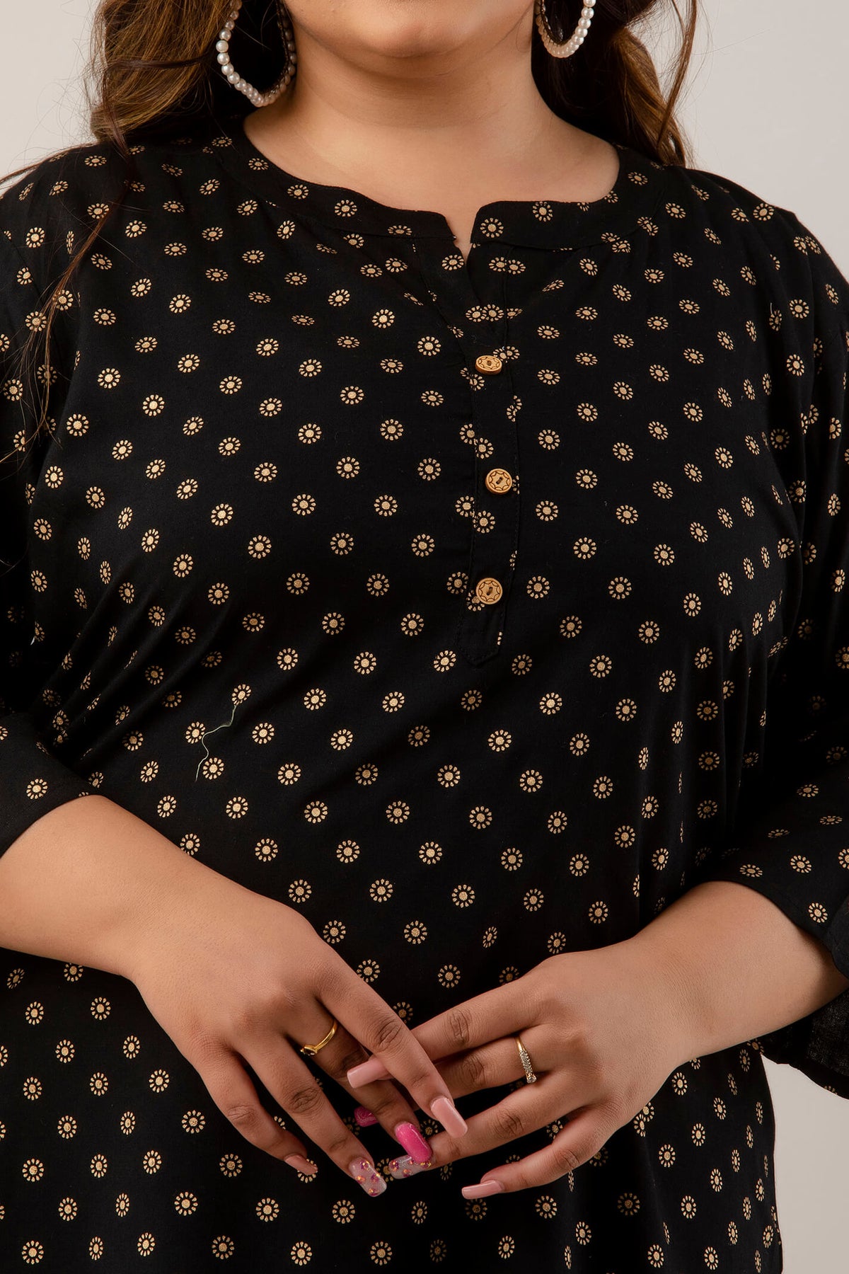 close up of plus size woman wearing a black polka dot tunic