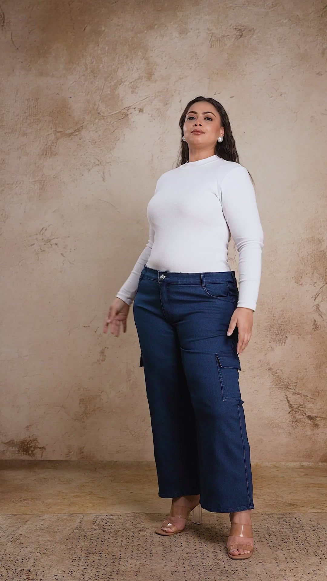 Plus size woman showcasing Curvisha buttoned blue denim pants with functional side pockets and premium stitching.