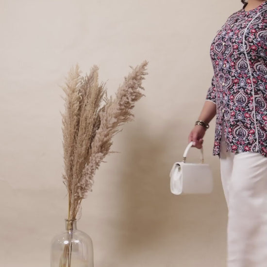 Crisp white cotton palazzo pants with a relaxed fit, styled with a floral tunic and white handbag.