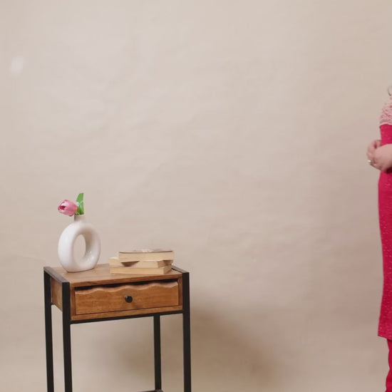 Plus size woman wearing a vibrant pink Kurti with intricate white embroidery on the neckline, paired with matching straight-fit pants.