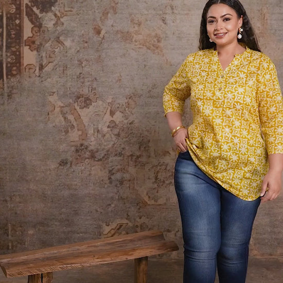 Curvisha plus size yellow short kurti with geometric print, styled with blue denim for a modern curvy fusion look.
