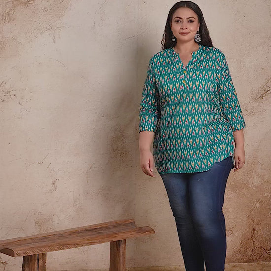 Curvisha plus size teal green Ikat print short cotton kurti top, styled with jeans for a stylish and comfortable casual outfit.